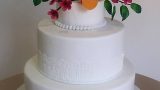 white wedding cake with a bouquet of flowers inspired by the invitation