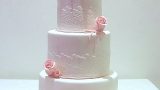 white wedding cake with pink roses topper