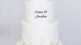 White tall wedding cake with floating tier, white roses and monogram