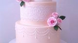 Peach wedding cake with pearls, white lace and flowers